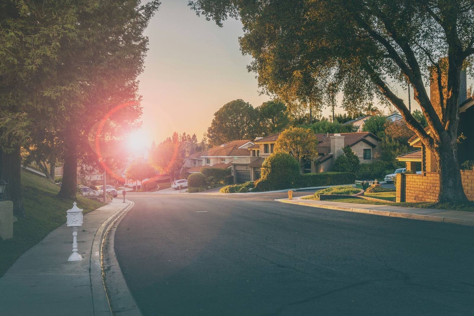 Illustrative residential street with detached houses in evening light; not an identified Ridge street